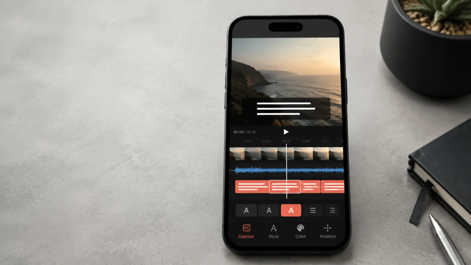 Smartphone displaying a video editing interface with subtitle lines, caption controls, and an audio waveform on a minimal desk.